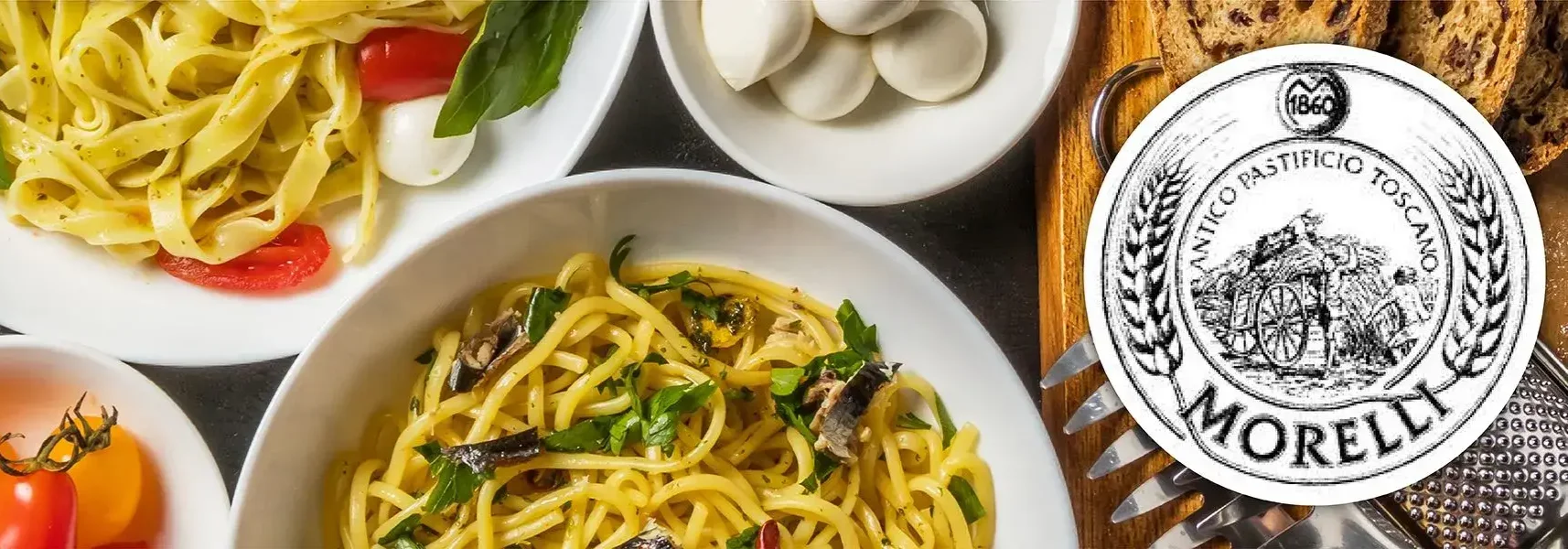Draufsicht auf Teller mit Pasta, Tomaten und Basilikum; links Bandnudeln, unten Spaghetti mit Sardinen, rechts…