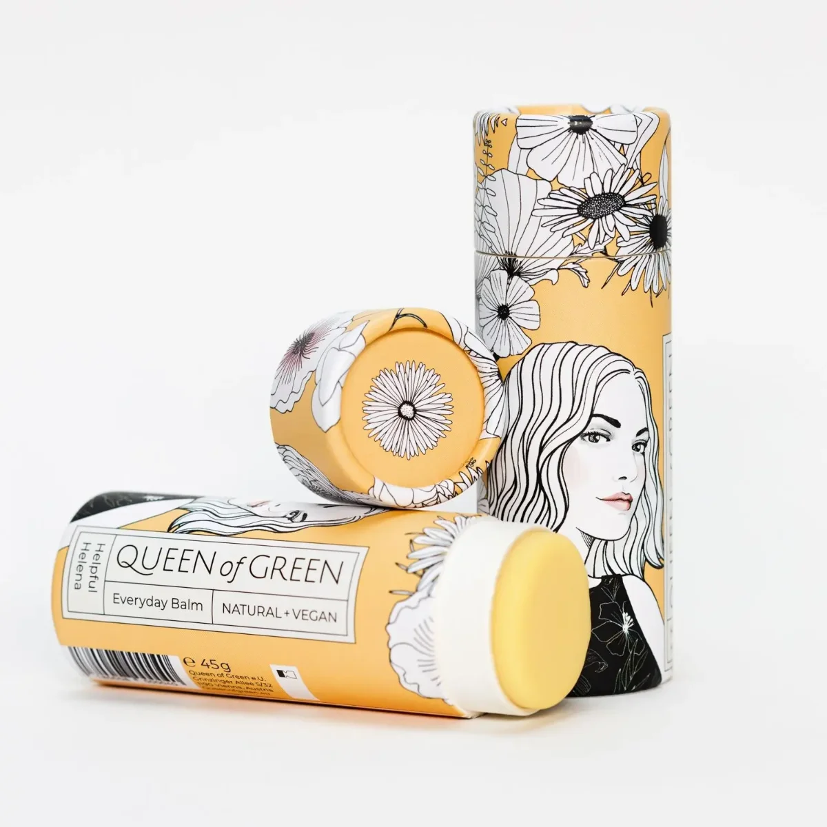 Drei gelb-weiß bedruckte runde Kartonhülsen mit Blumenzeichnungen und einer Frauenporträt-Illustration, eine davon liegt…