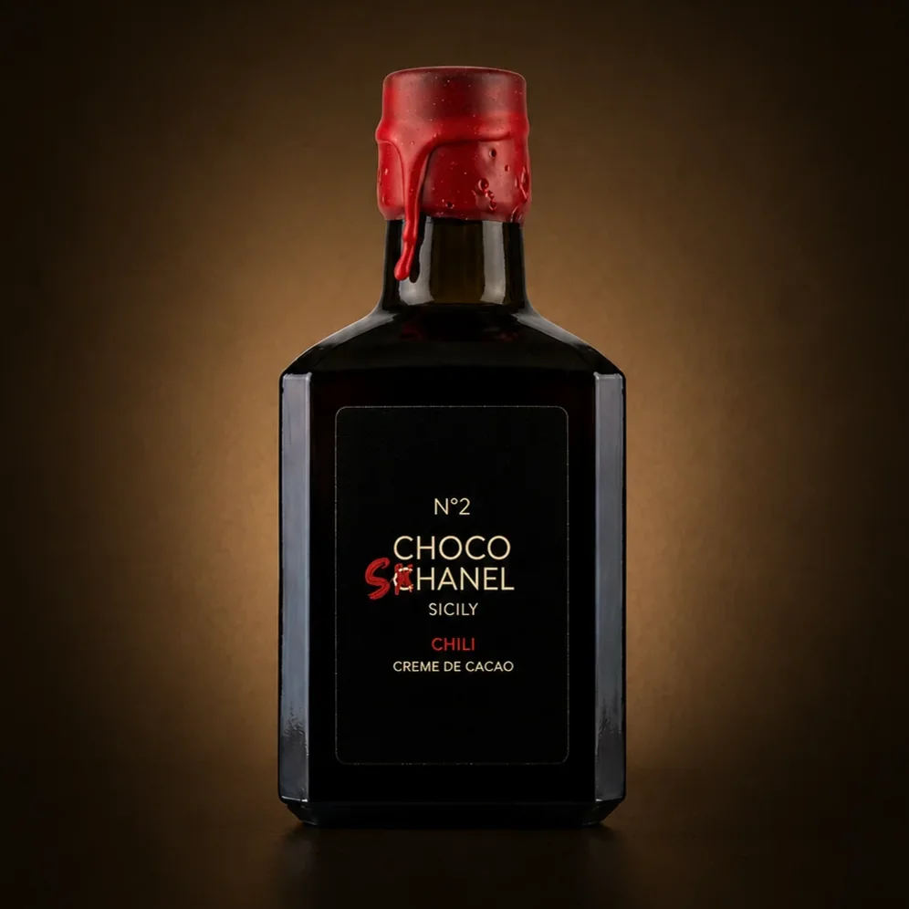 Schokoladenlikör Choco Schanel No 2 Chili in dunkler Glasflasche mit rotem Verschluss, vor warmem Hintergrund.