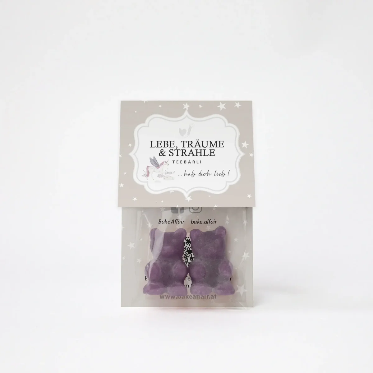 Teebär Geschenkset: zwei violette Fruchtgummi-Bärchen in Organzabeutel, oben Kartonkarte mit Spruch „Lebe, träume & strahle