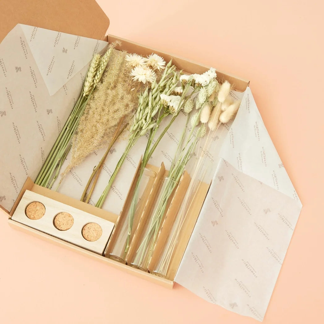 Trockenblumen Briefkasten geöffnet: flache Kartonbox mit getrockneten Blüten in Weiß und Grün, zwei kleine Vasen mit…