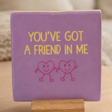 Lila Keramikfliese 10×10 cm mit gelbem Text „YOU'VE GOT A FRIEND IN ME