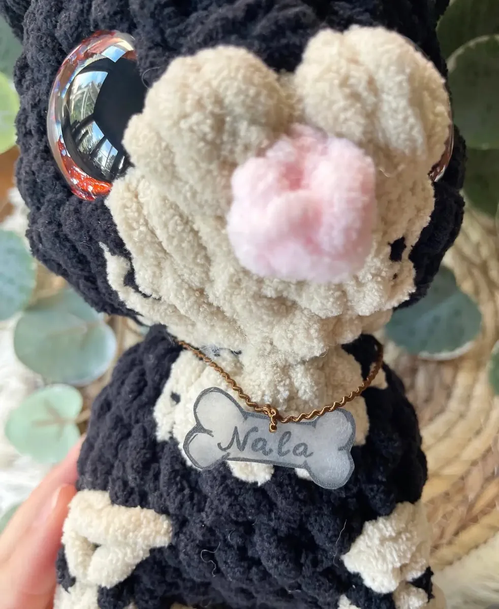 Gehäkelter Hund mit Creme und Schwarz, rosa Nase, glänzenden Augen, personalisiertes Halsband mit Name „Nala
