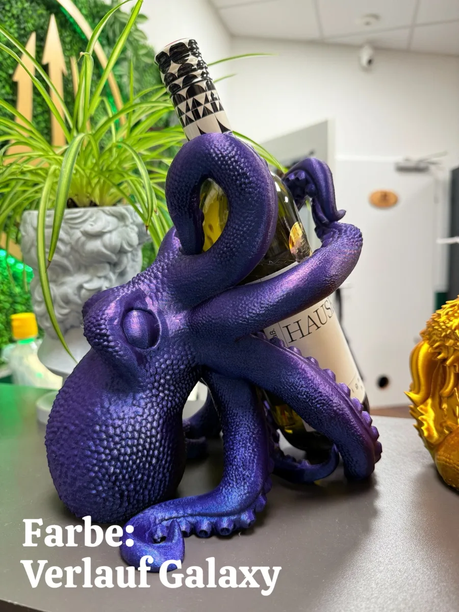 Violetter Kraken-Flaschenhalter mit strukturierter Oberfläche hält eine Weinflasche, neben grüner Pflanze und goldener…