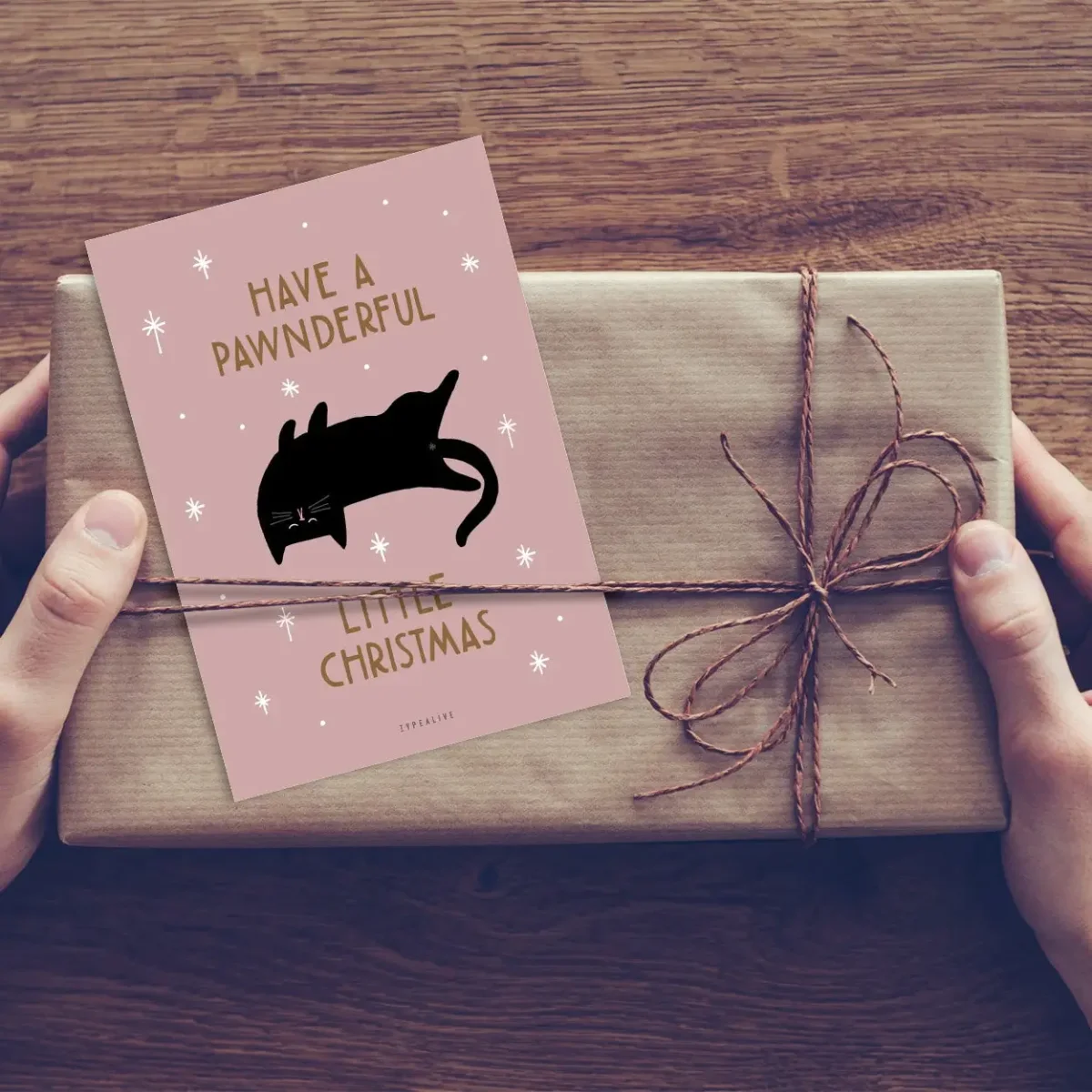 Rosa Weihnachtskarte mit schwarzer Katze und goldenem Text „Have a Pawndeful Christmas