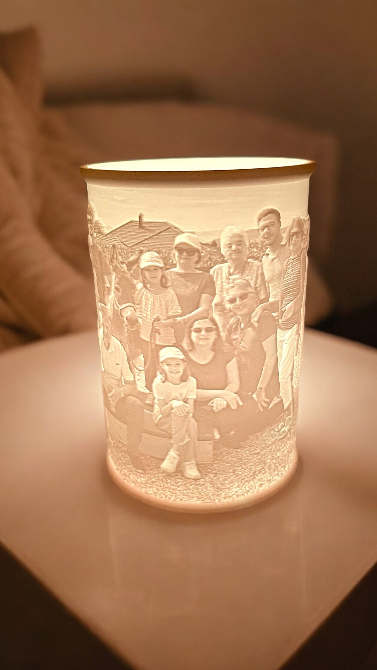 Zylindrisches Lithopan mit Familienportrait, von innen beleuchtet, zeigt fein gravierte Gesichter und Figuren in Licht- und…