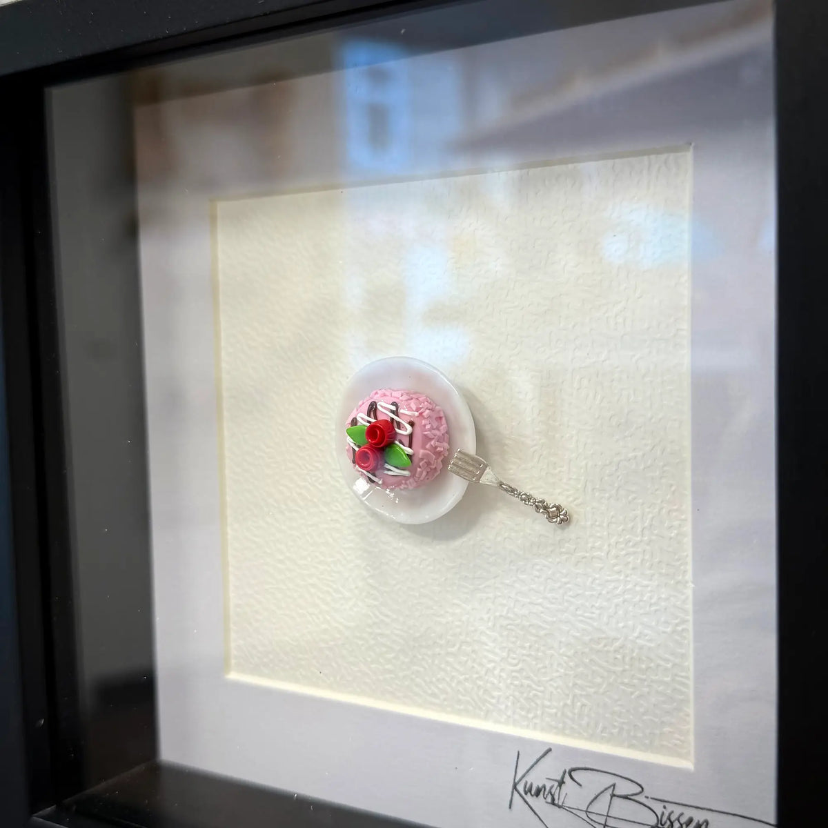 Miniatur-Erdbeertorte mit roten Rosen auf weißem Teller und silbernem Besteck, von oben fotografiert im schwarzen…