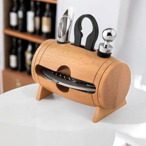 Holzfass mit vier Weinaccessoires: Kellnermesser, Flaschenverschluss, Weinkragen und Ausgießer stecken oben ein, darunter…