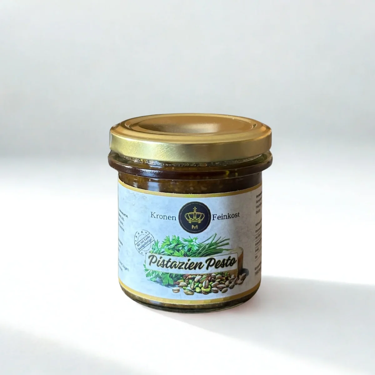 Pistazien Pesto von Kronenfeinkost im Glas mit goldenem Deckel, dunkelgrüne Paste sichtbar