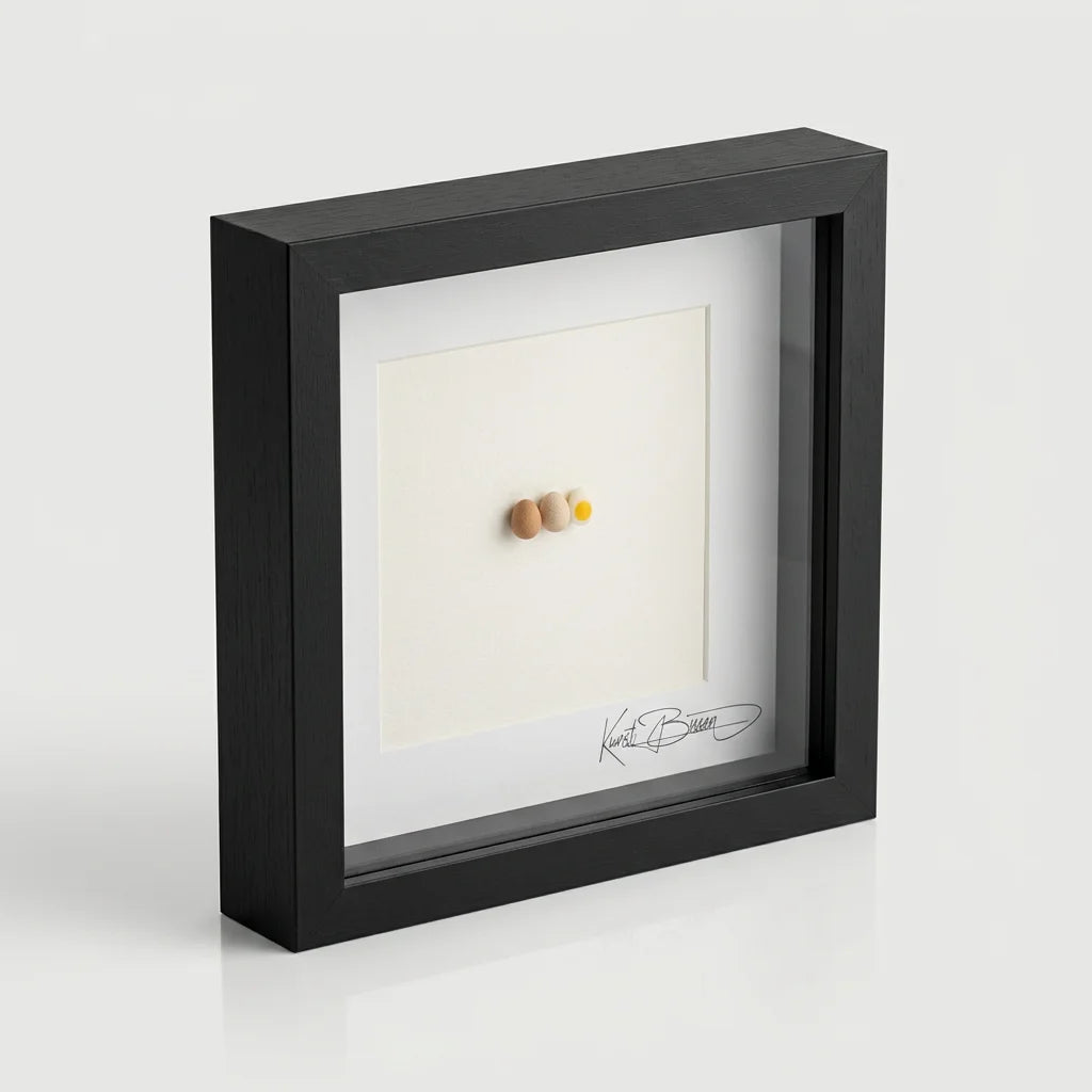Ei Miniatur im schwarzen Holzrahmen: drei handmodellierte Polymer-Clay-Eier auf cremefarbenem Passepartout, signiert.