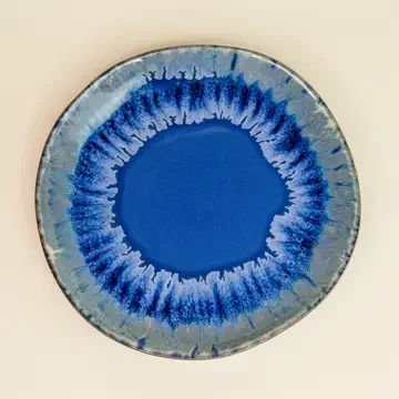 Kleiner Teller Keramik, Draufsicht: tiefblaue Mitte, Ränder in hellem Blau mit weißen, laufenden Glasurstreifen.