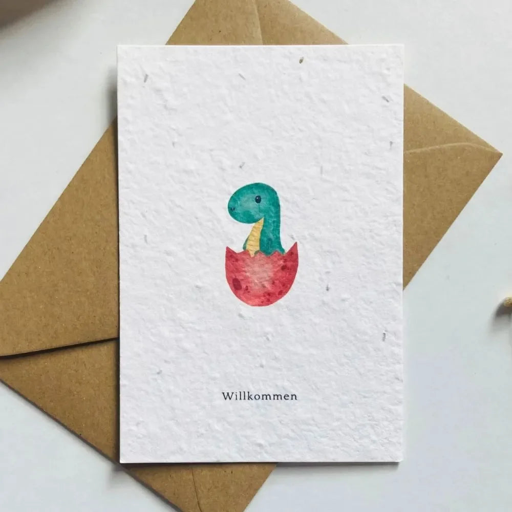 Geburtskarte Saatpapier mit handgemaltem Dino im roten Ei, Schriftzug „Willkommen