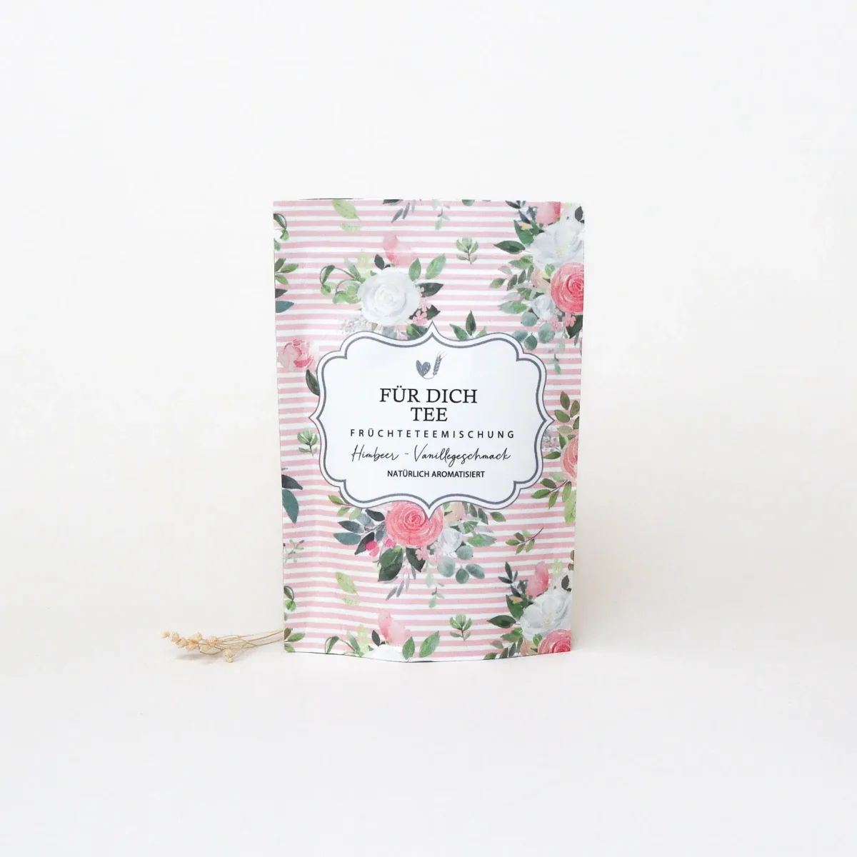 Früchtetee Himbeer Vanille in rosa gestreifter Papiertüte mit Blumenmuster und Kordel