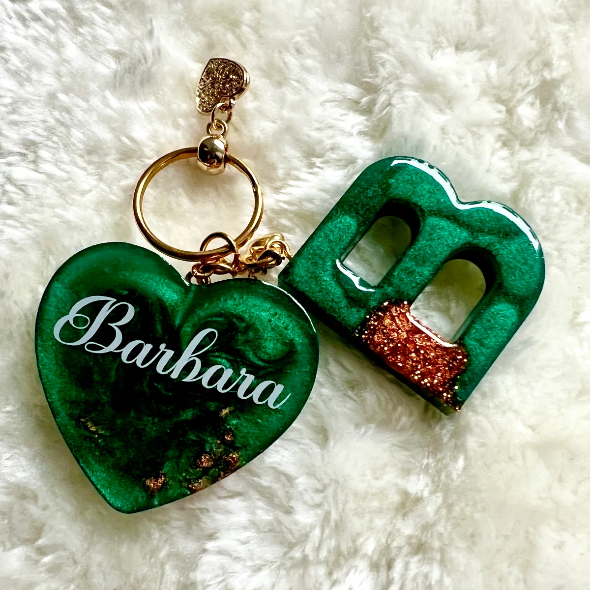 Schlüsselanhänger Herz mit Namen: grünes Herz mit weißer Schrift „Barbara“ und goldenem Ring, daneben ein grünes…