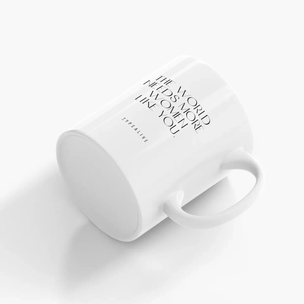Weiße Keramiktasse mit schwarzem Schriftzug, schräg von oben fotografiert, weißer Henkel sichtbar.