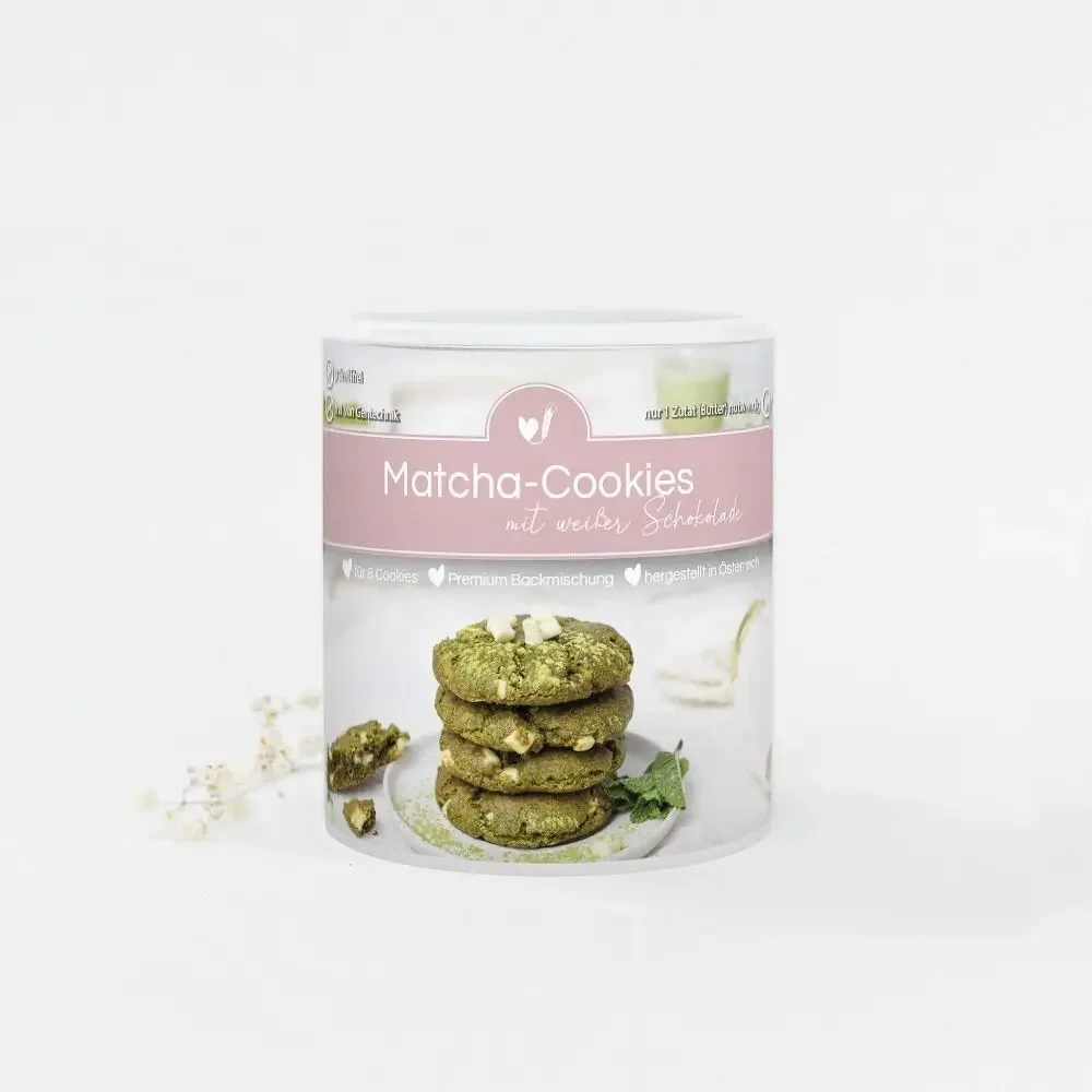 Backmischung Matcha-Cookies in weißer Dose mit rosa Band, gestapelte grüne Cookies mit weißer Schokolade auf der…