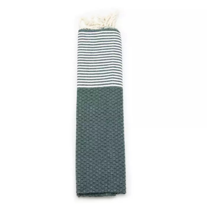 Fouta in Grün und Weiß, zusammengerollt: Oben Streifen, unten Wabenmuster, mit cremefarbenen Fransen oben.